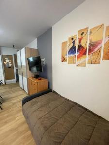 ein Schlafzimmer mit drei Gemälden an der Wand in der Unterkunft Studio Galija in Poreč