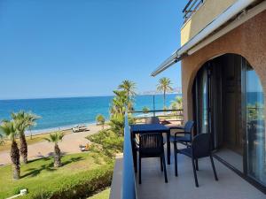 balcón con mesa y sillas y vistas a la playa en FantaSea House Salobreña, en Salobreña