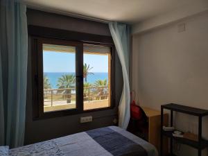 1 dormitorio con ventana y vistas al océano en FantaSea House Salobreña, en Salobreña