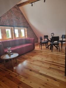 a living room with a purple couch and tables at Apartament Relax in Toruń