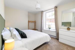 a bedroom with a white bed and a window at Old School House, Winchester in Winchester