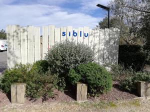 a sign for a subilu sign in front of a fence at CHEZ SEB & BELINDA, Séjour TOUT CONFORT dans environnement CALME et VERDOYANT in Saint-Julien-en-Born