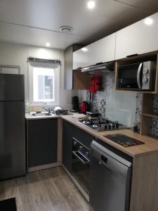 uma cozinha com um lavatório e um fogão forno superior em CHEZ SEB & BELINDA, Séjour TOUT CONFORT dans environnement CALME et VERDOYANT em Saint-Julien-en-Born