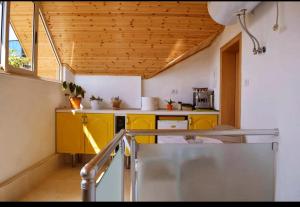una cucina con armadi gialli e soffitto in legno di Tirana Central GuestHouse a Tirana