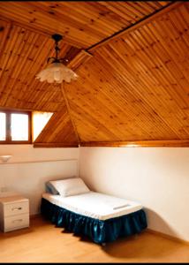 a bed in a room with a wooden ceiling at Tirana Central GuestHouse in Tirana