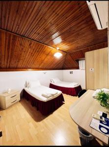 a room with two beds and a wooden ceiling at Tirana Central GuestHouse in Tirana