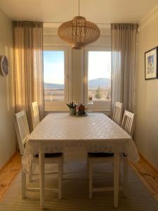 a dining room table with chairs and a large window at Flugumýri 2 in Varmahlid