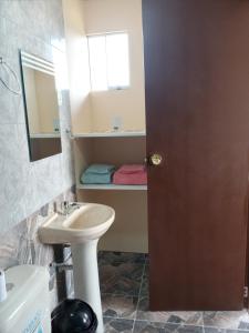 a bathroom with a sink and a toilet and a mirror at Casa huerta Stuber in Arequipa