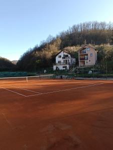 a tennis court with houses in the background at Kuršumlijska banja apartman in Kuršumlija