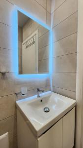a bathroom with a white sink and a mirror at Solar Rooms and Apartments in Himare
