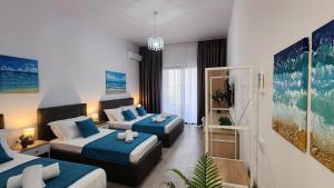 Habitación de hotel con 2 camas con sábanas azules en Solar Rooms and Apartments, en Himare