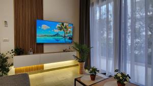 a living room with a tv on a wall at Solar Rooms and Apartments in Himare