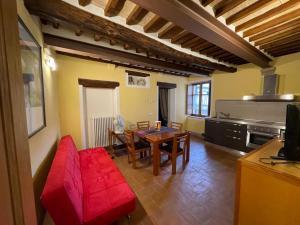 sala de estar con mesa y sofá rojo en Valdorcia, en San Quirico dʼOrcia