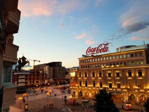 a city with a cocacola sign on top of a building at MIKA Square in Skopje