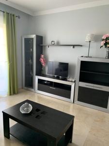 a living room with a tv and a coffee table at Residencial Duquesa Fase 1 in Manilva
