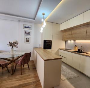 a kitchen with a table and a dining room at APARTMAN FLORENCE in Mirijevo