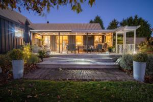 einen Hinterhof mit einer Terrasse und einem Haus in der Unterkunft Alpine Rock B&B in Te Anau