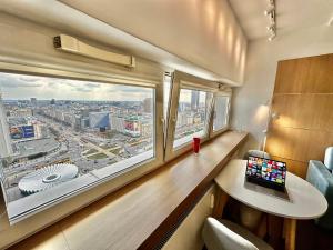 a room with a window and a laptop on a desk at TOP metro x2 fast WiFi 400 Mbs 70’TV Netflix HBO Max AppleTV+ Disney+ in Warsaw