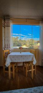 ein Esszimmer mit einem Tisch und einem großen Fenster in der Unterkunft Casa huerta Stuber in Arequipa
