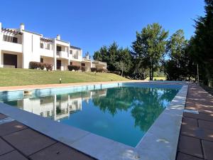 a swimming pool in front of a house at Golf Villa Alvor By CORAL in Alvor