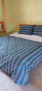 uma cama com um edredão azul e branco em INTERNO 12 em Vercelli