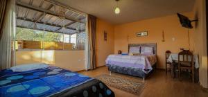 een slaapkamer met een bed, een tafel en een raam bij Casa huerta Stuber in Arequipa