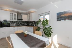 a kitchen with a table and a dining room at Apartments Ana in Biograd na Moru