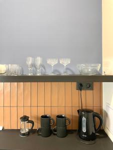 a shelf with wine glasses and coffee makers on it at Heart & Cherry Residency in Budapest