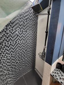 a shower with black and white tile on the wall at MINT APARTMENTS in Zadar