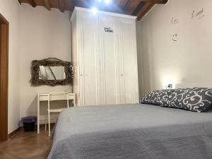 een slaapkamer met een bed, een kast en een spiegel bij B&B L'angolino in Usigliano