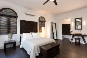 a bedroom with a bed and a table and two windows at Vive Zen Queen Room in Miami