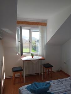 um pequeno quarto com uma mesa e uma janela em Casa Popa em Gura Humorului