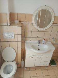 a bathroom with a toilet and a sink and a mirror at Central Station House in Santa Marinella
