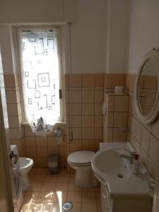 a bathroom with a toilet and a sink and a window at Central Station House in Santa Marinella