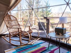 a room with a rocking chair and a lamp on a table at SlavskoGlamping in Slavske