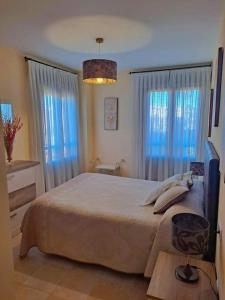 1 dormitorio con 1 cama grande y cortinas azules en APARTAMENTO MANUELA RESIDENCIAL **VISTA ESURI** en Ayamonte