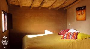 Una cama con dos almohadas encima en una habitación. en Berber Oasis Camp, en Oulad Driss