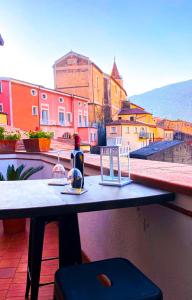 馬拉泰亞的住宿－B&B La Terazza Sul Cielo di Maratea，阳台上的桌子,上面有一瓶酒和眼镜