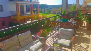 a balcony with a couch and chairs on a patio at APARTAMENTO MANUELA RESIDENCIAL **VISTA ESURI** in Ayamonte