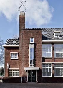 a brick building with a clock on top of it at College Hotel Alkmaar in Alkmaar