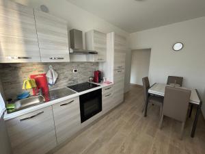 a kitchen with a dining table and a kitchen with white cabinets at Sweet Home in Bolzano