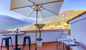 馬拉泰亞的住宿－B&B La Terazza Sul Cielo di Maratea，阳台配有桌椅和遮阳伞。