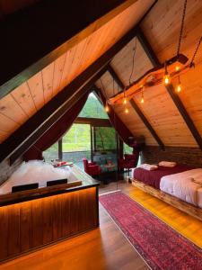 an attic bedroom with a large bed in a room at Tanura Bungalows in Çamlıhemşin