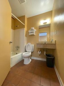 La salle de bains est pourvue de toilettes, d'un lavabo et d'une baignoire. dans l'établissement El Camino Motel, à Tallahassee