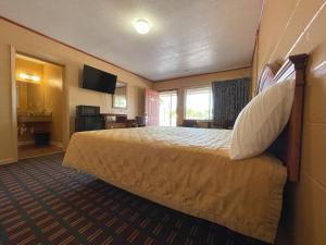 Habitación de hotel con cama y TV en El Camino Motel, en Tallahassee