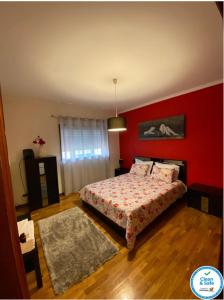 a bedroom with a bed and a red wall at Oporto Cavadas House in Porto