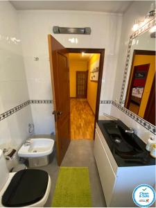 ein Bad mit einem schwarzen Waschbecken und einem WC in der Unterkunft Oporto Cavadas House in Porto + 10 Fotos