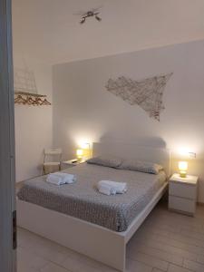 ein Schlafzimmer mit einem Bett mit zwei weißen Handtüchern darauf in der Unterkunft Casa Andolina White in Noto