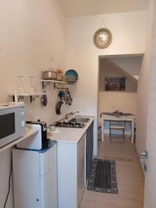 eine Küche mit einer Spüle, einer Mikrowelle und einem Tisch in der Unterkunft Casa Andolina White in Noto