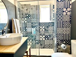 a bathroom with a shower with blue and white tiles at Taormina Casa Liliana in Taormina +17 photos